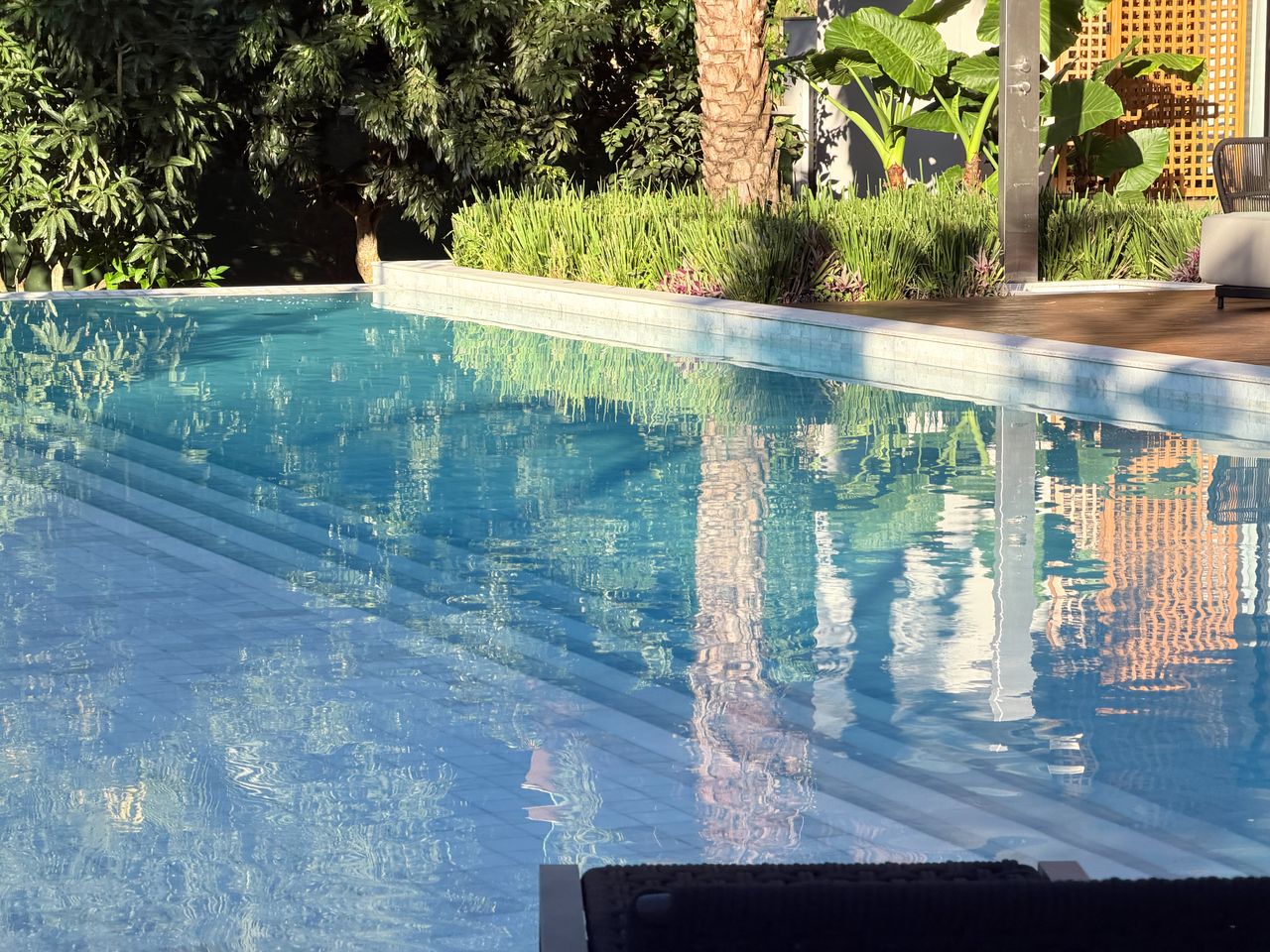 Reflexo da fachada de muxarabi na água da piscina